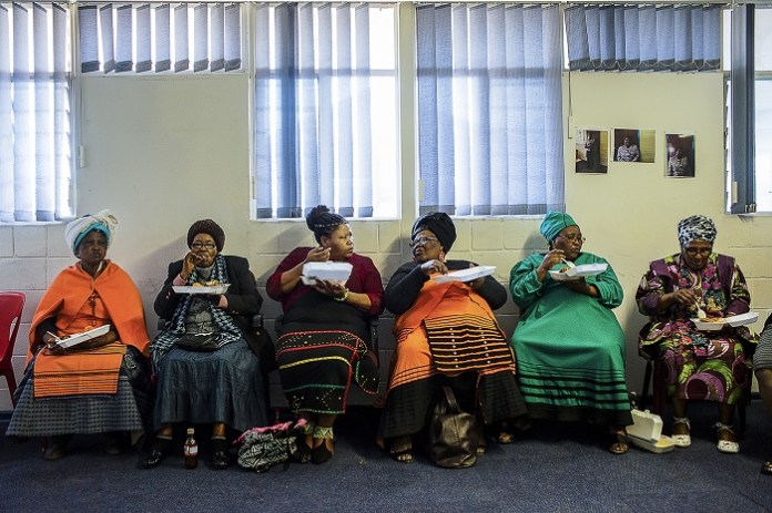 South Africa, Cape Town, Township of Khayelitsha. Some women with South African traditional clothes, during a political meeting organized in the township of Khayelitsha one of the poorest areas of Cape Town. During the meeting, have been offered free food and alcohol to all present. South Africa, has one one of the highest overweight and obesity rate in sub-Saharn Africa: two-thirds of the population are overweight, driven by increasingly sedentary lifestyles, a rise in disposable income and the popularity of cheap junk food, sugary drinks, fat- and salt-laden crisps and fried chicken who are becoming popular in South African diets.
